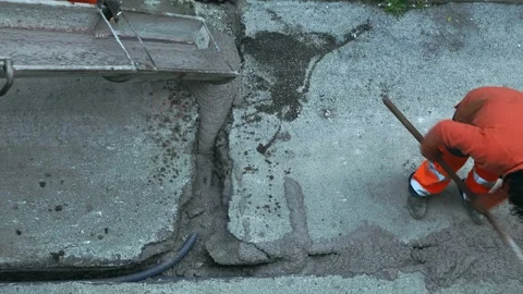 Worker pours colored concrete that is poured from a truck mixer to fill the c Stock Footage 159652260