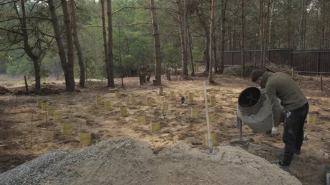 Worker Pours Concrete in Forest During Afternoon Construction Project at Stock Footage 276091831