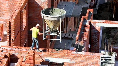 A worker pours a door overlap in a brick wall on a construction site Stock Footage 137086402
