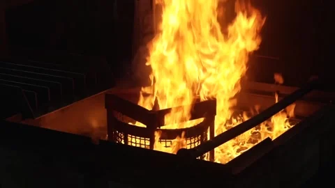 Worker pours glowing molten chain material into a quenching trough filled with Vídeos de archivo 339123484