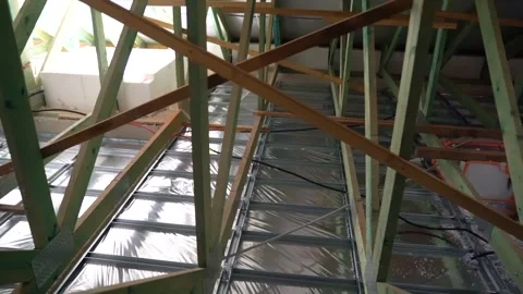 Worker prepares attic area for insulation installation inside roof structure 動画素材 312325429
