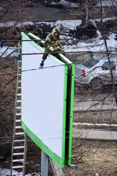 Worker prepares billboard to installing new advertisement. Foto stock