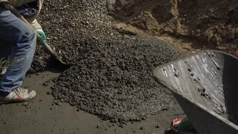 A worker prepares a concrete mixture with a shovel Stock Footage 307384099