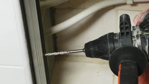 Worker prepares for drilling hole in door system closeup Stock Footage 304404600