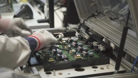 Worker prepares printed circuit boards with components for testing and Stock Footage 252645268