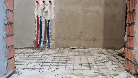Worker prepares rebar wire mesh for concrete floor reinforcement. Indoor Stock Photos