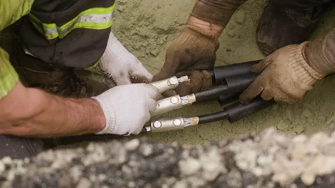 The worker is preparing a new cable for replacement on the power transmission Stock Footage 244644017
