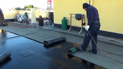 Worker preparing part of bitumen roofing felt roll Video stock 90783711