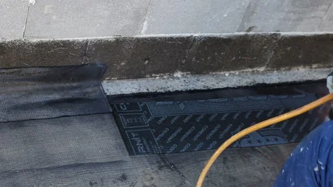 Worker preparing part of bitumen roofing felt roll Stock Footage 98300621