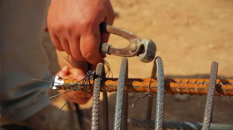 Worker preparing steel poles at construction site.He bundle wire on steel rod Stock Footage 62224518