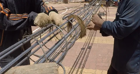 Worker preparing steel poles at construction site. He bundle wire on steel ro Stock Footage 91878110