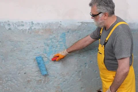 Worker preparing wall for tile gluing Stock Photos
