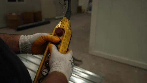 A worker presses a button on a remote control and lifts the load up. Stock Footage 247702806