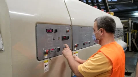 Worker, presses buttons on the control panel of the machine. Stock Footage 257435838