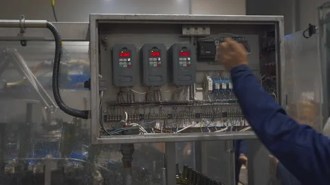 Worker presses multiple buttons on the automated production machine panel Stock Footage 220044359