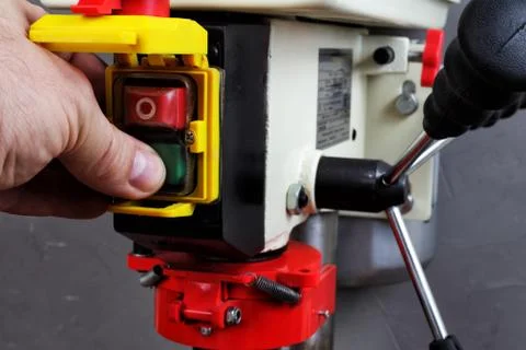 Worker presses the start button on the drilling machine Stock Photos