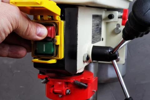 Worker presses the stop button on the drilling machine Foto stock
