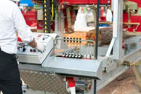 Worker pressing buttons on CNC machine control board in factory. Partially mi Stock-Fotos