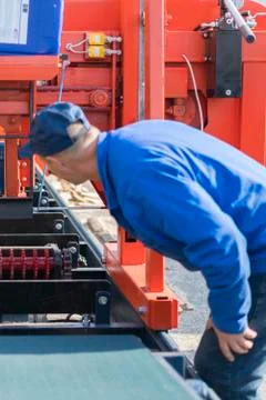 Worker pressing buttons on CNC machine control board in factory. Worker works Stock Photos