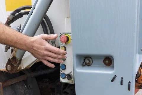 Worker pressing green start button on truck tail lift control panel 写真素材