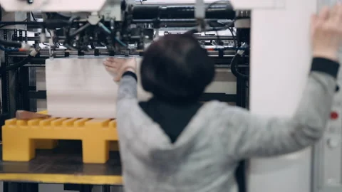 A worker in a printing press prepares printing material. Stock Footage 197463268