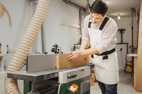 Worker processes board on woodworking machine Foto stock