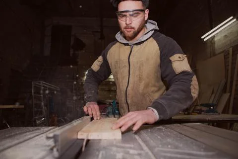 A worker processes a Board on a woodworking machine Stock Photos