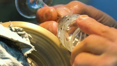 A worker processes a glass on the machine. The disk is rotating. A person cuts a Stock Footage 195029901