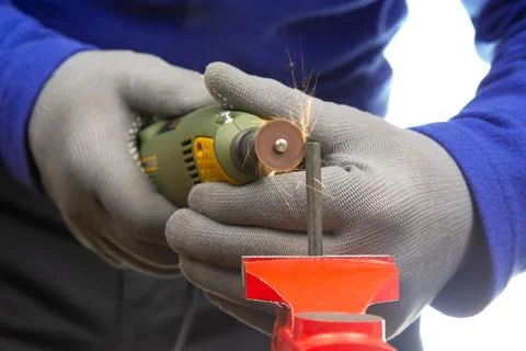 Worker processes metal with engraving drill close-up. The work of the dreme.. Stock Photos