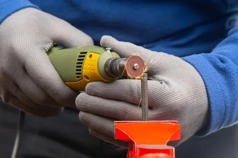 Worker processes metal with engraving drill close-up. The work of the dreme.. Foto stock