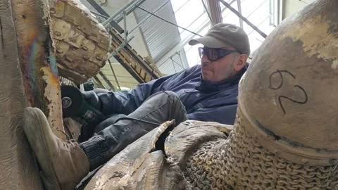 A worker processes a monument to Alexander Nevsky in the studio of his helme Stock Footage 157781349