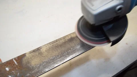 A worker processes a piece of metal that is clamped in a vice with a circular sa Stock Footage 156283409