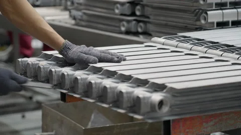 The worker processes the radiator part, removes the burr after casting, prepares Stock Footage 181965463