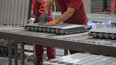 The worker processes the radiator part, removes the burr after casting, prepares Stock Footage 201987343