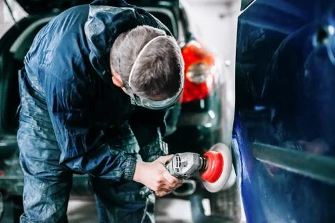 Worker processes the surface of the car door Foto stock