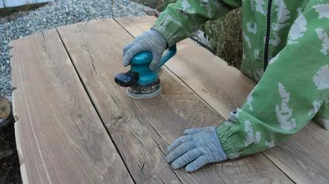 A worker processes wood with a sander Stock Photos