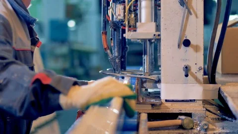 Worker processing plastic detail at industrial machine. Video stock 83340649