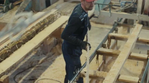 Worker is processing the timber logs using a woodworking tool in a workshop Stock Footage 238414502