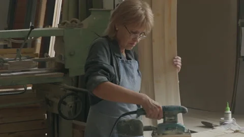 Worker producing timber part using grinding instrument at carpentry workshop Stock Footage 234684076