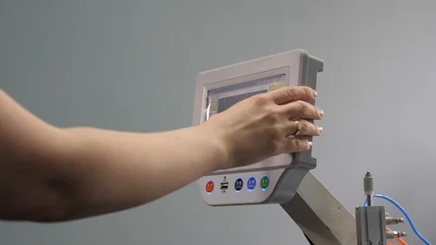 Worker is programming a sewing machine with a CNC using a tablet computer. close 库存影片 119238075