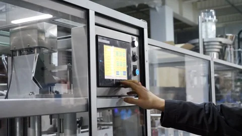 Worker programs the machine on a tablet computer. Machine control at the factory Stock Footage 107273887