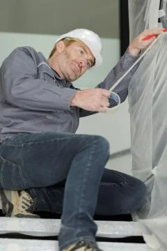 Worker protecting objects with masking tape Stock Photos