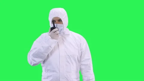 A worker in a protective chemical suit is talking on the radio. Video stock 146805507
