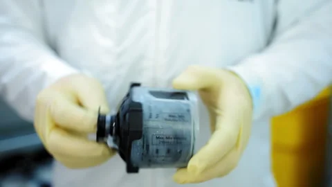 Worker in protective clothes and rubber gloves shakes paint in the container for 스톡 동영상 321445232
