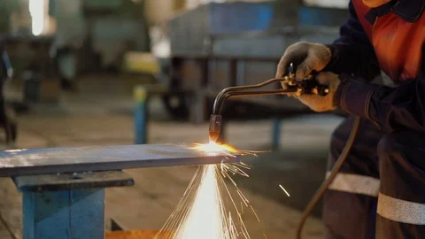 Worker in protective form cuts a sheet of metal with a oxigen gas torch Stock Footage 110699545