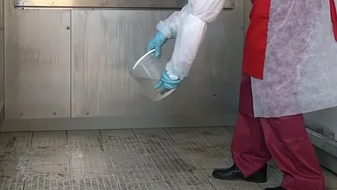 Worker in Protective Gear Pours Liquid Onto the Floor in Industrial Setting Stock Footage 320138212
