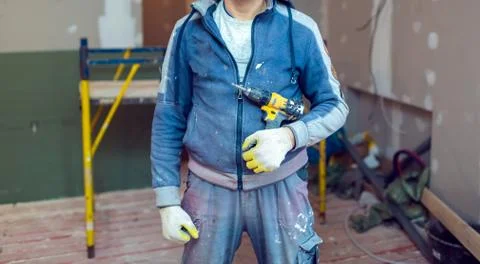 Worker with protective gloves is holdind a perforator with some drywall screws Stock-Fotos