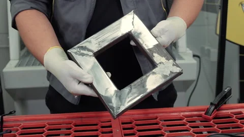 Worker in protective gloves holding shiny square metal frame, polished steel Stock Footage 317882825