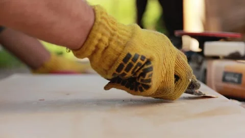 Worker in protective gloves scraping and preparing a wooden board for const.. Stock Footage 342501069