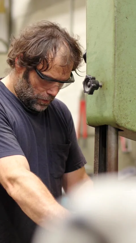 Worker with protective goggles using an machine in a factory Stock Footage 260013165
